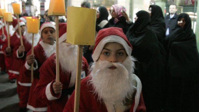 Noel baba kostümü giymiş çocuklar Şam'daki karnavalda yürüyorlar