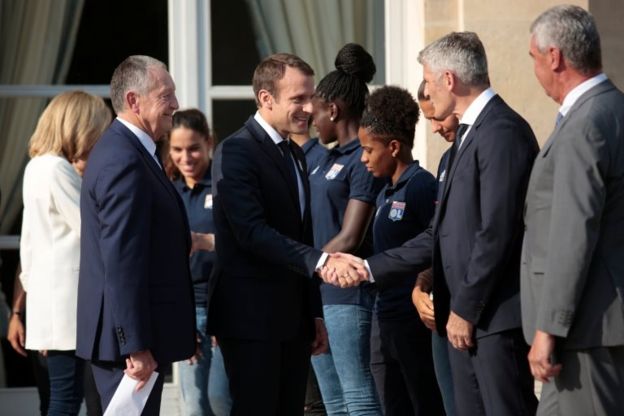 Macron, Lyon futbol takımı çalışanlarıyla el sıkışıyor.